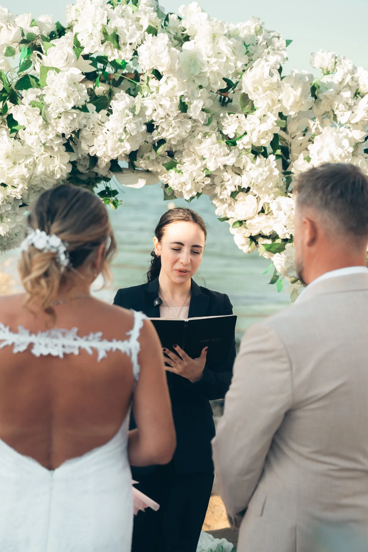 Guest beach wedding ceremony under a white floral arch in Hurghada